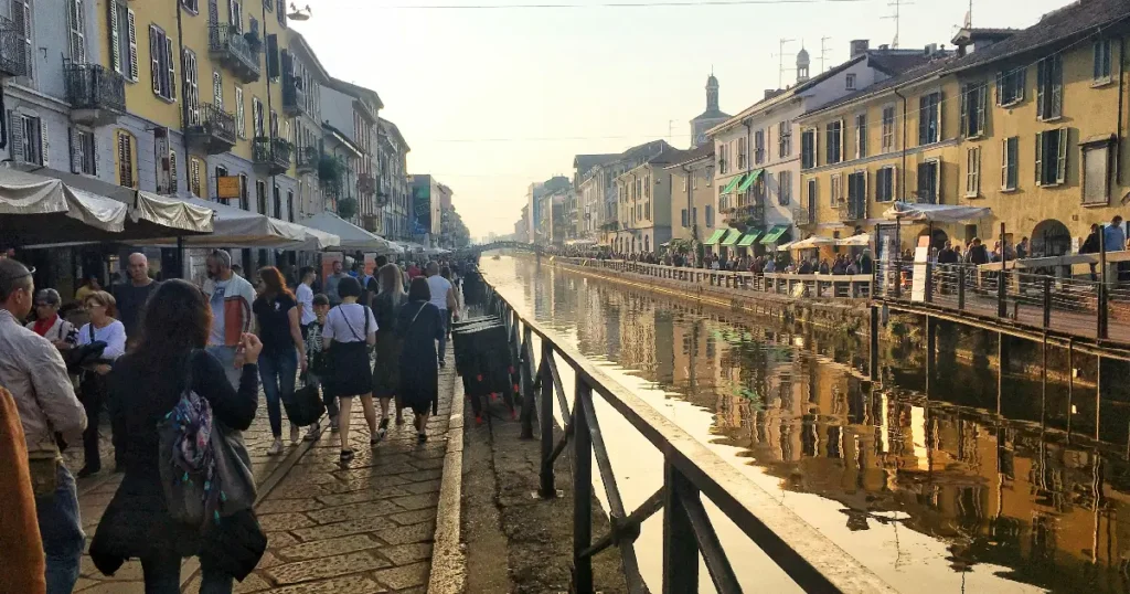 ミラノのナヴィリオ地区にある運河と人で賑わうカフェや飲食店が並ぶ風景